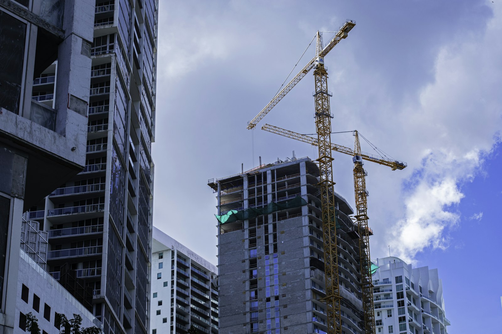 Construction cranes over a city skyline